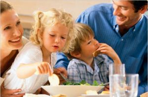 Una famiglia felice e contenta di riunirsi a tavola alle 7.00 del mattino, tipica immagine a pubblicità per prodotti della colazione